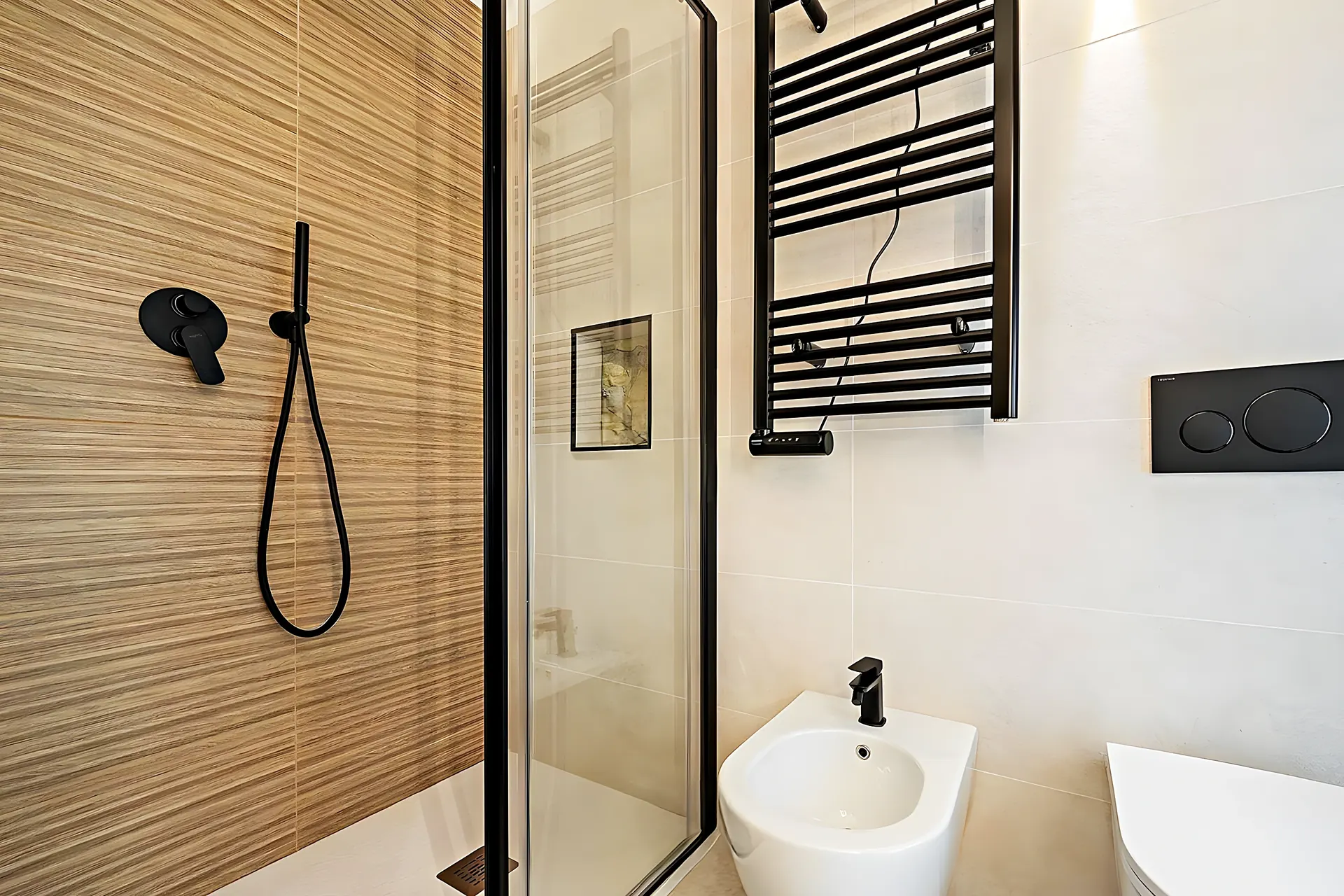 Baño con madera cebrada y grifería negra — reforma en Sitges